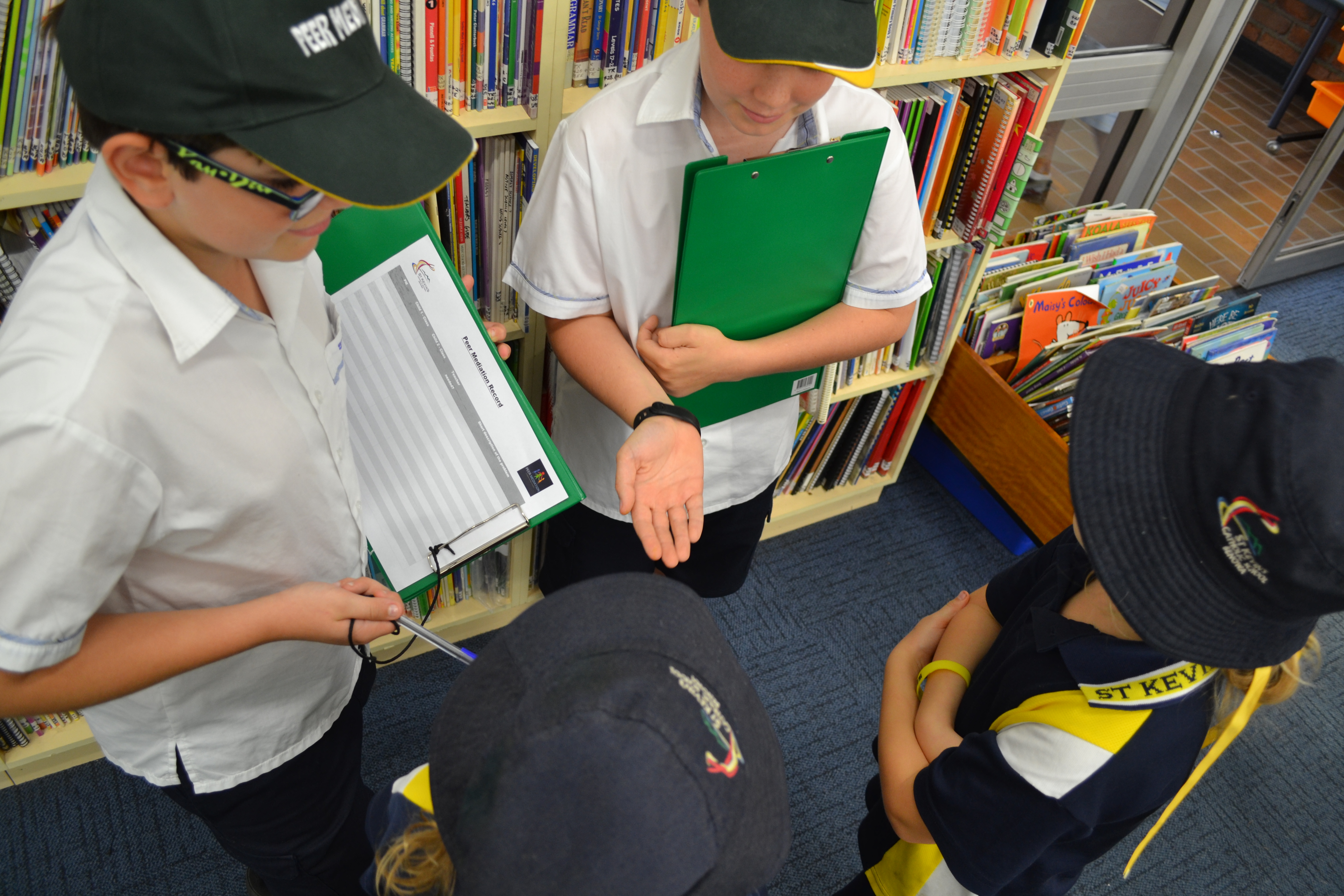 Four students standing in the library. 